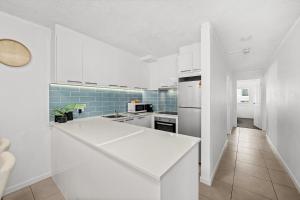 a kitchen with white appliances and blue tiles at Surfers Paradise- meters from the beach! in Gold Coast +31 photos