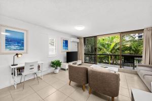 a living room with a couch and a table at Surfers Paradise- meters from the beach! in Gold Coast
