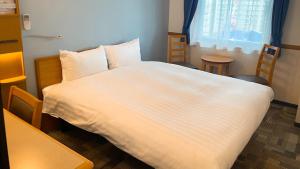 Postel nebo postele na pokoji v ubytování Toyoko Inn Mito-eki Minami-guchi