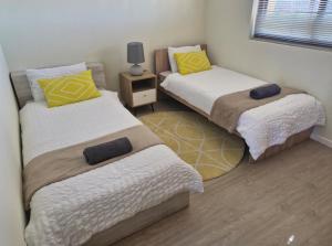 two beds in a small room with a table at Island Club apartment in Century City - 305 Ibiza in Cape Town +32 photos
