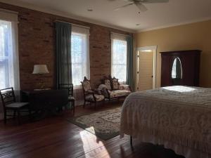 a bedroom with a bed and a couch and windows at Tanglewood Inn in Greenville