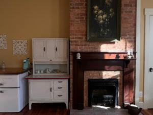 a living room with a fireplace and a kitchen at Tanglewood Inn in Greenville
