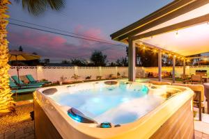 a hot tub on the patio of a house at NEW The Mesquite Retreat on Oak Entertainers Oasis in Scottsdale