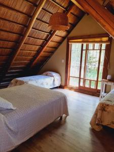 a bedroom with two beds and a large window at El Charanguito Casa Quinta in Capilla del Señor