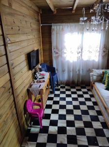 a room with a checkered floor with a table and a couch at Sobrado Rustico iguacu in Foz do Iguaçu +14 photos