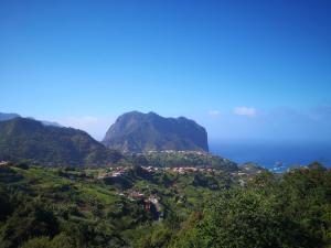 a view of a mountain with the ocean in the background at House in the montain Casa do Cabeço in Machico +7 photos