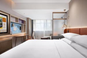 a hotel room with a bed and a desk at Home2 Suite by Hilton Harbin Central Street in Harbin