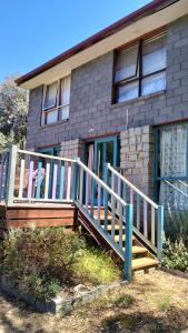 a house with a wooden staircase in front of it at Cheerful Bush House in Hepburn Springs