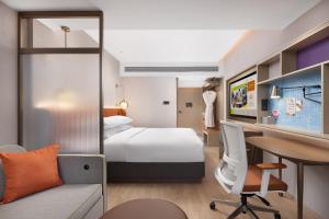 a hotel room with a bed and a desk at Home2 Suite by Hilton Harbin Central Street in Harbin