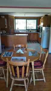 a kitchen with a wooden table and two chairs and a table at Cheerful Bush House in Hepburn Springs +8 photos