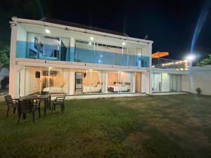 メルガルにあるCasa Quinta Melgarの夜のテーブルと椅子のある大きな家