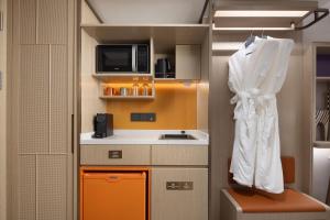 a small kitchen with a sink and a microwave at Home2 Suite by Hilton Harbin Central Street in Harbin