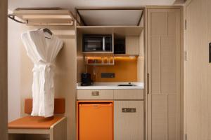 a small kitchen with an orange and white kitchen at Home2 Suite by Hilton Harbin Central Street in Harbin