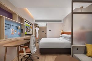 a hotel room with a bed and a desk at Home2 Suite by Hilton Harbin Central Street in Harbin