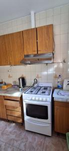 a kitchen with a white stove and wooden cabinets at Casa del centro in San Martín +6 photos