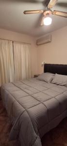 a bed in a bedroom with a ceiling fan at Casa del centro in San Martín