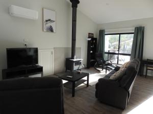 un soggiorno con divano e camino di Halls Gap Cottages a Halls Gap