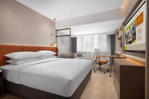 a hotel room with a large bed and a desk at Home2 Suite by Hilton Harbin Central Street in Harbin