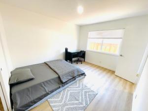 een slaapkamer met een bed, een stoel en een raam bij Cozy Home in the Valley 3 in San Jose