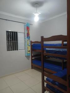 una habitación con tres literas y una ventana en Casa Recanto em Itanhaém, en Itanhaém