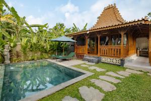a villa with a swimming pool and a house at Suraya Ubud Villa in Ubud