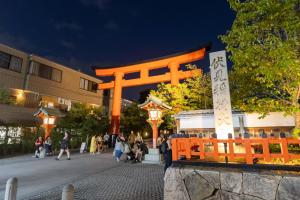 an orange torii gate in front of a building at Miro Fusimiinari Tei South in Kyōto
