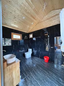 un bagno con un lavandino e una vasca in una stanza di SkyHeaven Jacuzzi Treehouse a Jibhi