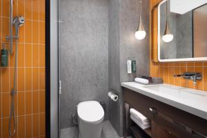a bathroom with a toilet and a sink and a mirror at Home2 Suite by Hilton Harbin Central Street in Harbin