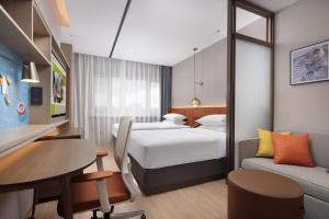 a hotel room with two beds and a table at Home2 Suite by Hilton Harbin Central Street in Harbin