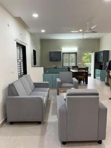 a living room with two couches and a kitchen at Achyuta Homestay in Tirupati