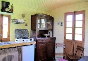 a kitchen with a sink and a stove top oven at Les Roulottes Du Lauragais in Montmaur