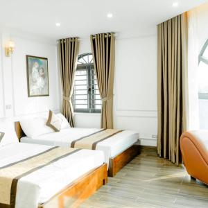 a hotel room with two beds and a couch at Trang Anh Hotel Bắc Giang in Bắc Giang