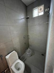 a bathroom with a toilet and a shower at Achyuta Homestay in Tirupati