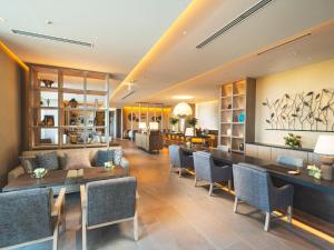 a lobby with a couch and tables and chairs at The Orion Hotel Motobu Resort & Spa in Motobu