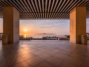 a view of the ocean from a building with a sunset at The Orion Hotel Motobu Resort & Spa in Motobu