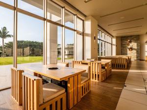 a restaurant with tables and chairs and large windows at The Orion Hotel Motobu Resort & Spa in Motobu
