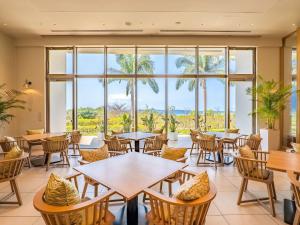 a restaurant with tables and chairs and a large window at The Orion Hotel Motobu Resort & Spa in Motobu