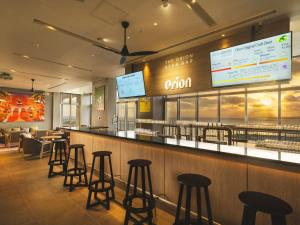a bar in a restaurant with stools at The Orion Hotel Motobu Resort & Spa in Motobu
