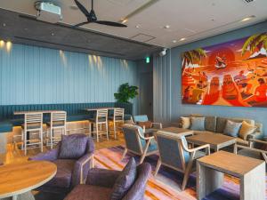 a restaurant with tables and chairs and a painting on the wall at The Orion Hotel Motobu Resort & Spa in Motobu