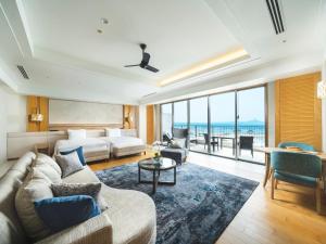 a hotel room with a bed and a couch at The Orion Hotel Motobu Resort & Spa in Motobu