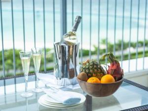 a table with a bowl of fruit and a bottle of wine at The Orion Hotel Motobu Resort & Spa in Motobu