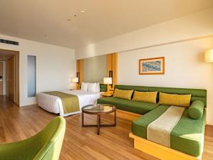 a hotel room with a couch and a bed at The Orion Hotel Motobu Resort & Spa in Motobu