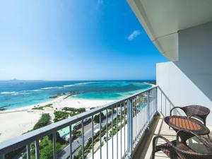 a balcony with two chairs and the beach at The Orion Hotel Motobu Resort & Spa in Motobu