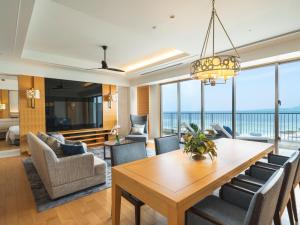 a dining room with a table and chairs and a view of the ocean at The Orion Hotel Motobu Resort & Spa in Motobu