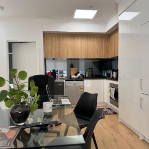 a kitchen and dining room with a glass table and chairs at Welcome home in St Albans