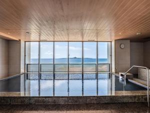 a swimming pool with a view of the ocean at The Orion Hotel Motobu Resort & Spa in Motobu