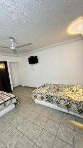 a bedroom with two beds and a flat screen tv at Hotel Nuevo Vallarta in Guadalajara