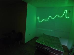 a dark room with a green neon sign on the wall at Departamento 3 - 1er piso Centro Pileta in Formosa