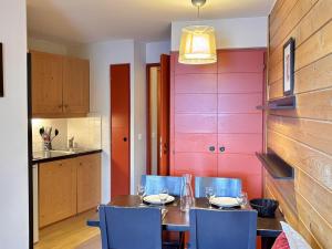 a dining room with a wooden table and blue chairs at Appartement 4 pers, balcon sud-est, quartier Falaise - FR-1-634-109 in Morzine
