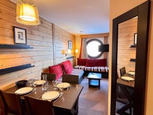 a dining room with a table and a couch at Appartement 4 pers, balcon sud-est, quartier Falaise - FR-1-634-109 in Morzine